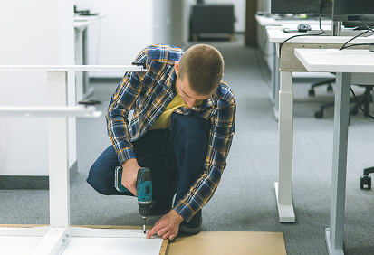 Man assembling furniture with drill